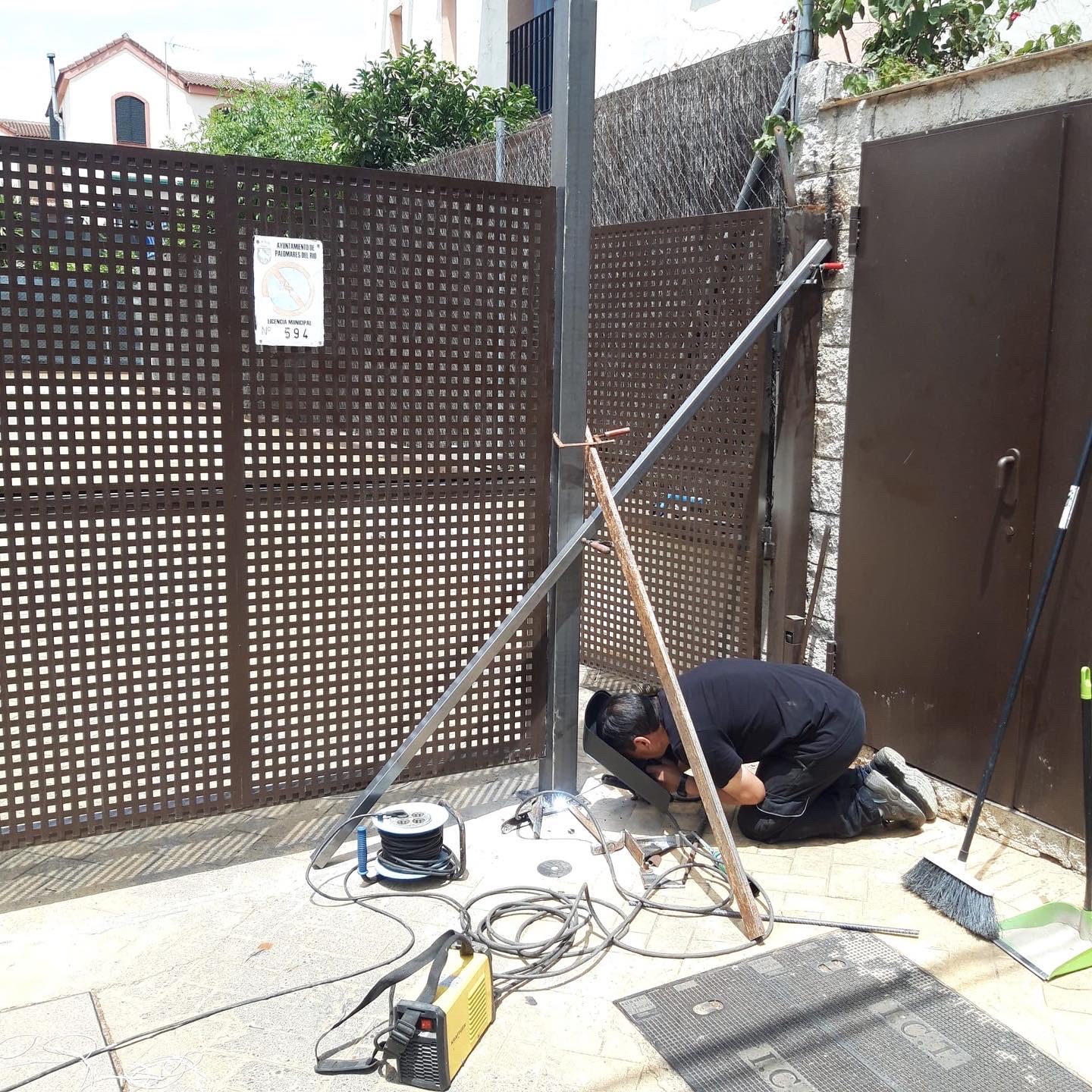 Técnico realizando el mantenimiento de una puerta automática batiente